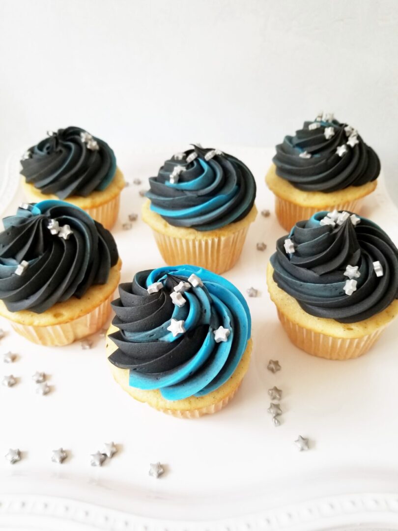 A close up of cupcakes with blue and black frosting