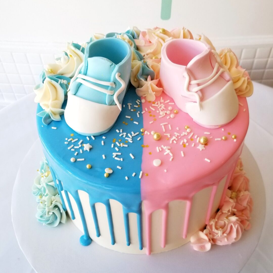 A pink and blue cake with shoe toppers