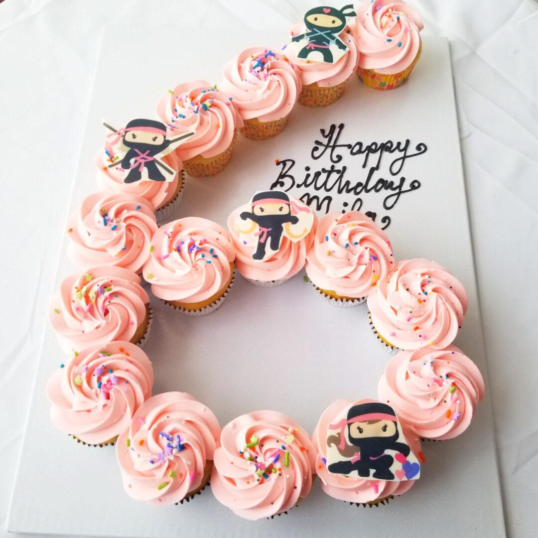 A cupcake cake with pink frosting and characters.