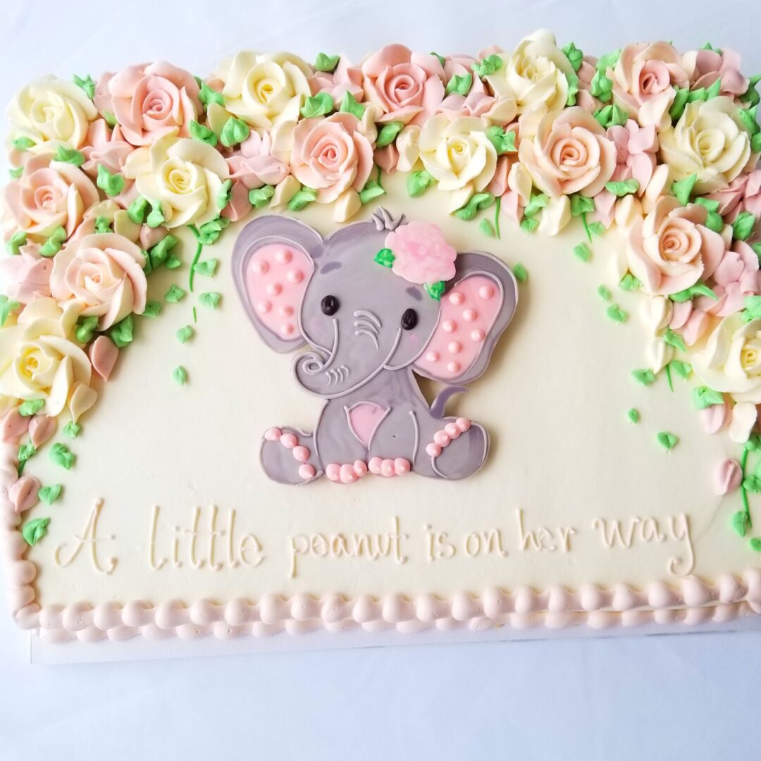 A pink cake with an elephant design