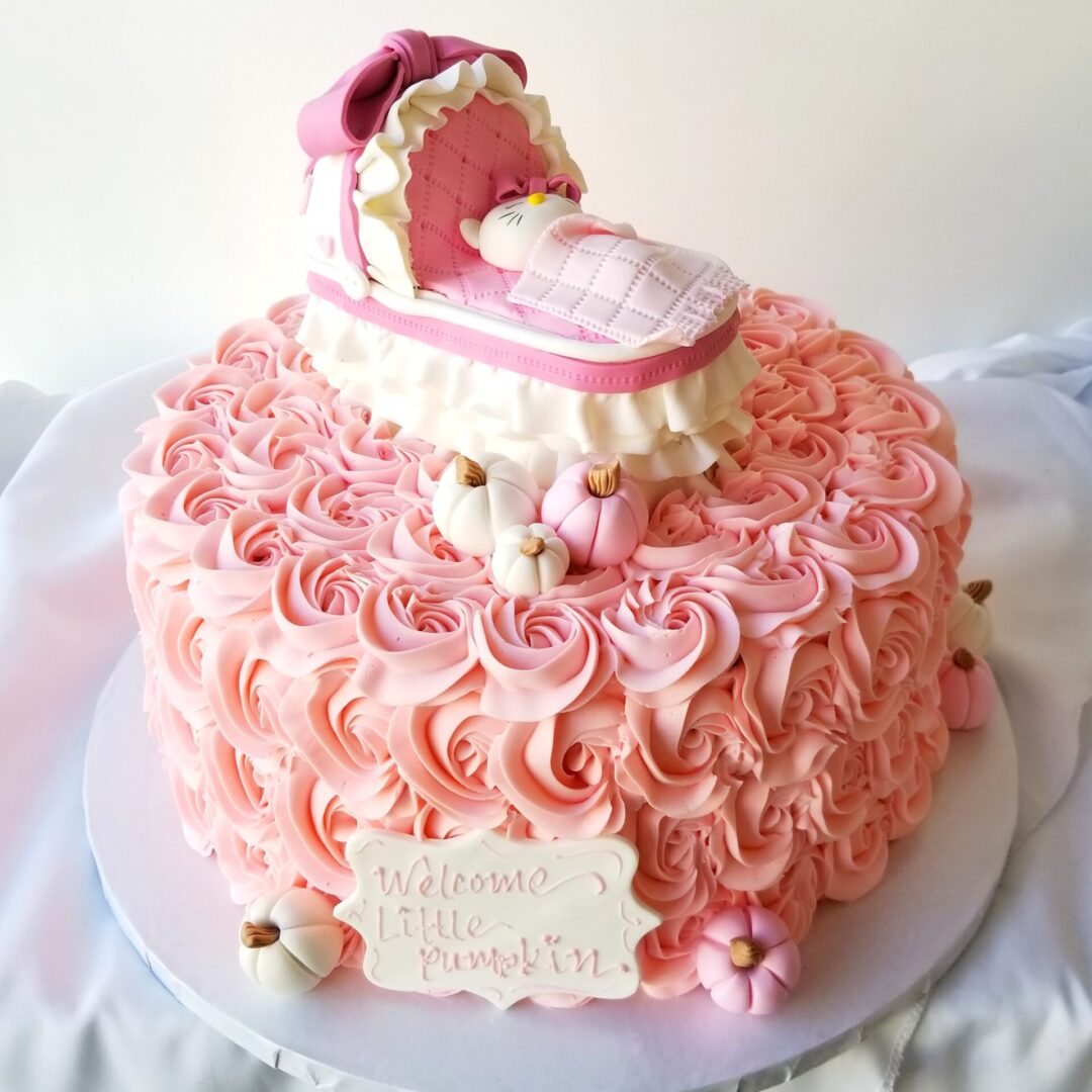 A cake with roses and a baby carriage topper