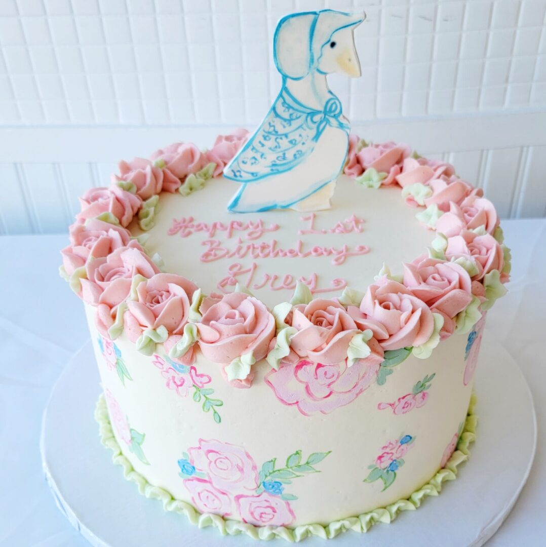 A pink cake with a mother goose topper