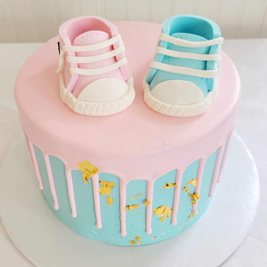 A blue and pink cake with a pair of shoes on top