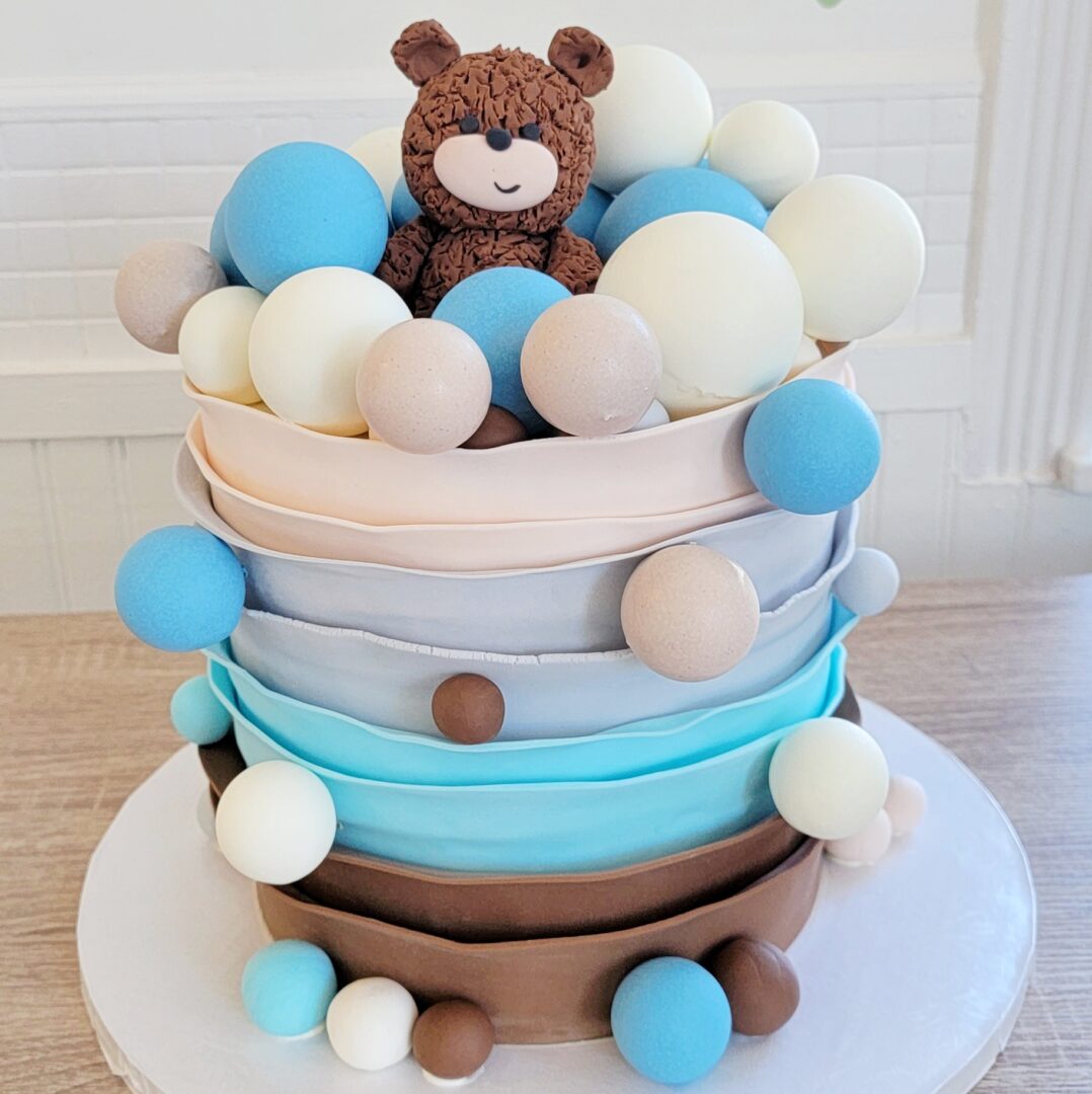 A layered cake with balls and a bear