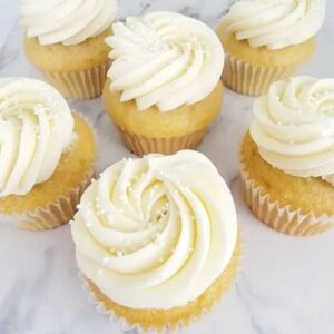 A close up of several cupcakes with white frosting.