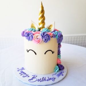 A unicorn cake with purple and yellow frosting.