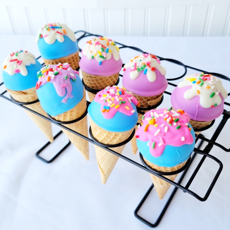 A tray of cupcakes with icing and sprinkles.