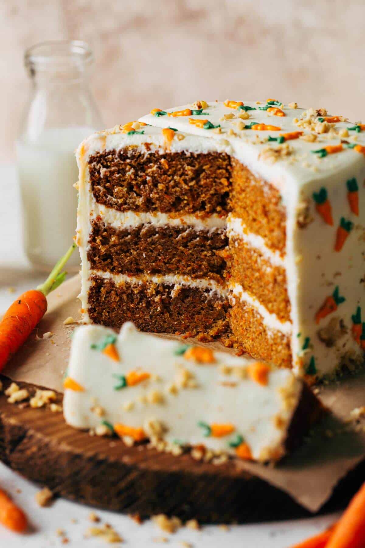 A carrot cake with white frosting and sprinkles.